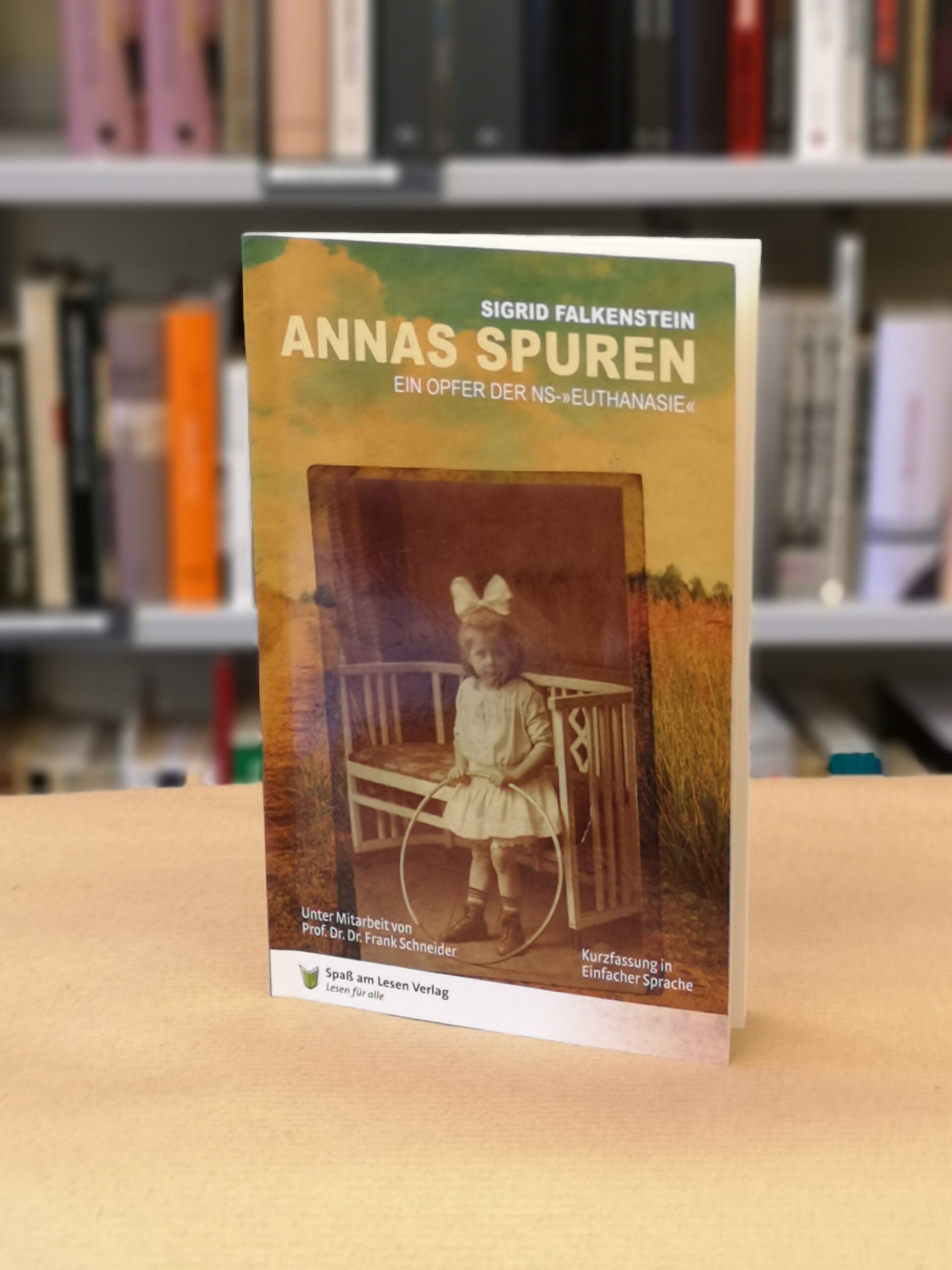 Auf dem Cover des Buch ist ein Foto von Anna und der Titel. Im Hintergund ein Bücherregal. Das Foto ist in Farbe.
